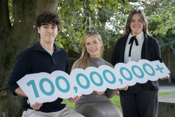 three people holding up a 10 million number sign